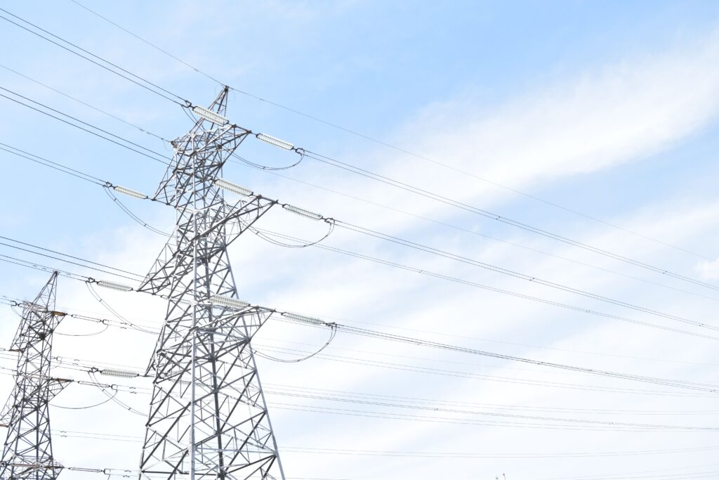 Steel transmission towers against blue sky, highlighting energy and electricity infrastructure.
